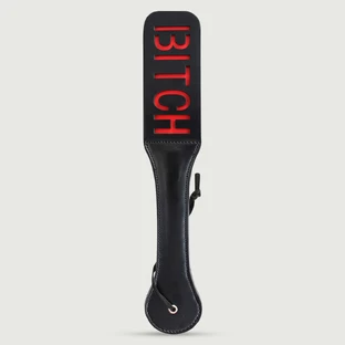 Paddle en simili cuir de la série Domme avec découpe « BITCH » et doublure rouge - Noir